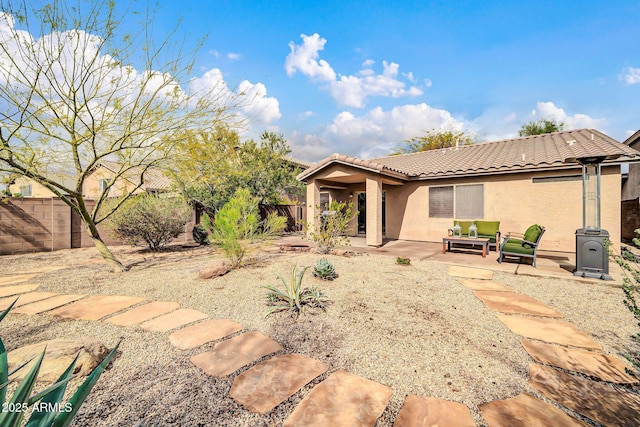 rear view of house with a tiled roof, a patio area, fence, and stucco siding