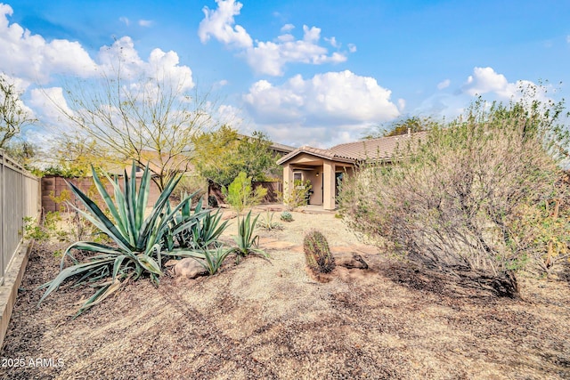 exterior space with stucco siding, a tile roof, and a fenced backyard