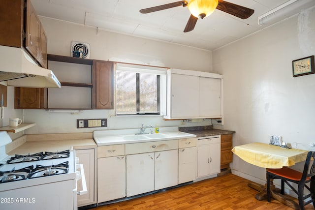316 B St, Bisbee, AZ 85603 - kitchen featuring white range with gas cooktop, open shelves, a ceiling fan, under cabinet range hood, and light wood-style floors