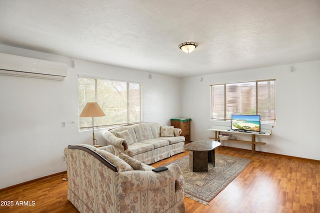316 B St, Bisbee, AZ 85603 - living area with a wall mounted air conditioner, wood finished floors, and baseboards