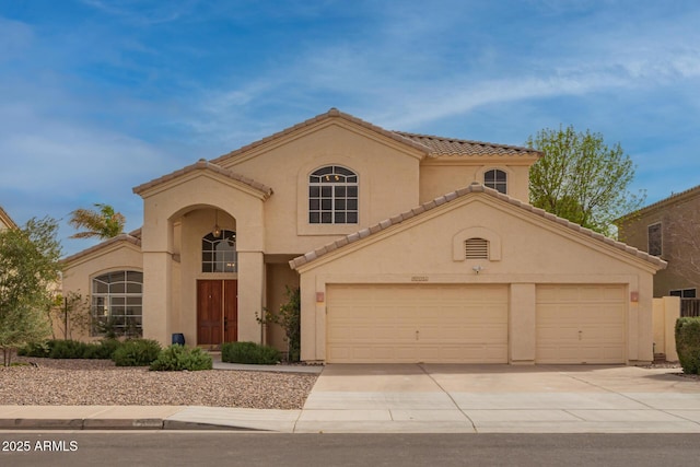 mediterranean / spanish home featuring a garage, concrete driveway, a tile roof, and stucco siding