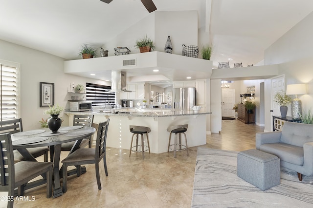 dining space with a ceiling fan, visible vents, high vaulted ceiling, and light tile patterned floors