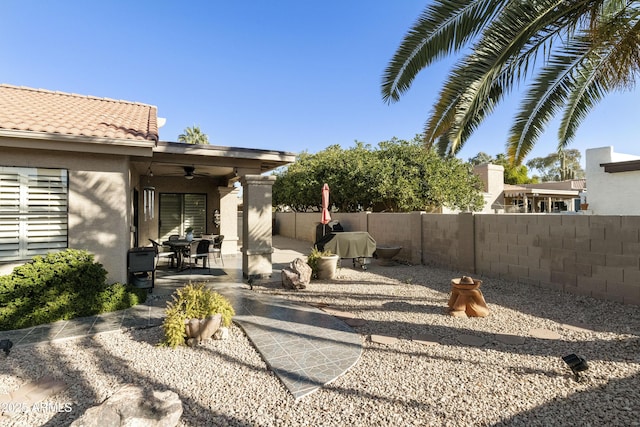 view of yard featuring a fenced backyard, a ceiling fan, and a patio