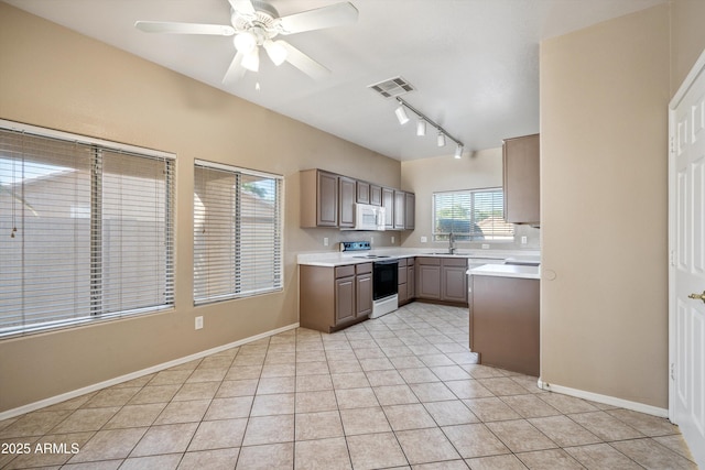 9422 W Monroe St, Peoria, AZ 85345 - kitchen with electric stove, white microwave, rail lighting, and light countertops