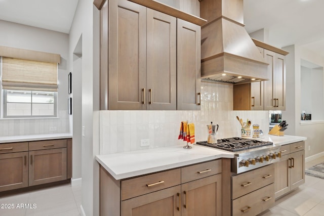 20797 W Rattler Rd, Buckeye, AZ 85396 - kitchen with custom exhaust hood, light tile patterned floors, stainless steel gas stovetop, tasteful backsplash, and light countertops