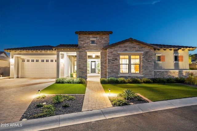 20797 W Rattler Rd, Buckeye, AZ 85396 - mediterranean / spanish house with an attached garage, a front lawn, driveway, a tile roof, and stone siding