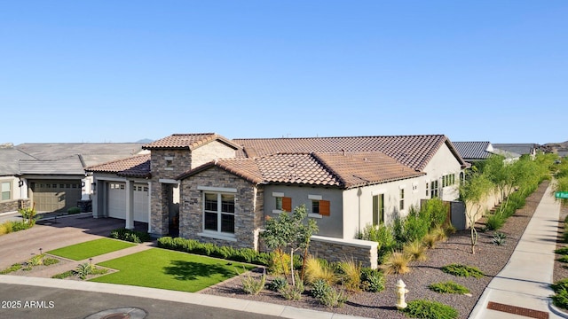 20797 W Rattler Rd, Buckeye, AZ 85396 - mediterranean / spanish-style home featuring a tiled roof, stucco siding, stone siding, a garage, and driveway