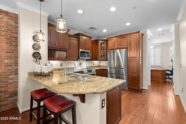 kitchen featuring visible vents, a sink, a peninsula, glass insert cabinets, and stainless steel appliances