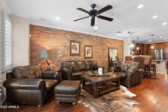 living area featuring ceiling fan, wood-type flooring, recessed lighting, and brick wall