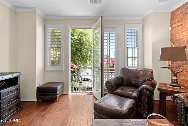 sitting room with crown molding, baseboards, hardwood / wood-style flooring, and visible vents
