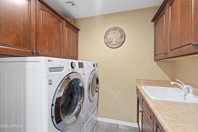 laundry area featuring visible vents, cabinet space, a sink, baseboards, and washer and clothes dryer