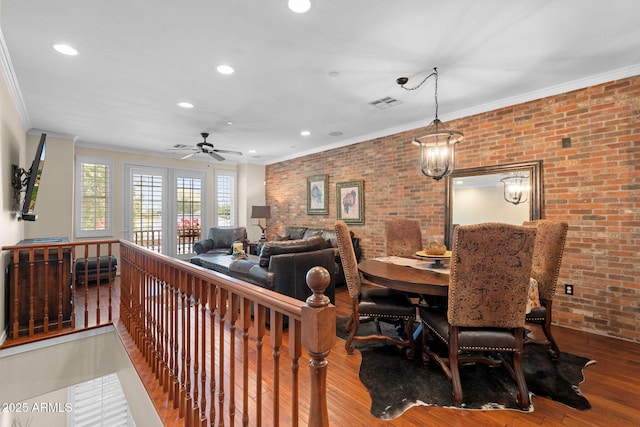 dining space featuring brick wall, visible vents, and ornamental molding