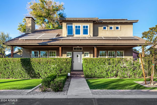 prairie-style house featuring a front yard and solar panels