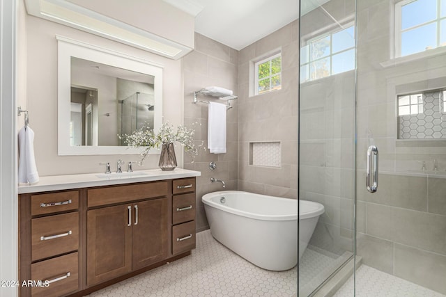 bathroom featuring tile patterned flooring, vanity, tile walls, and plus walk in shower