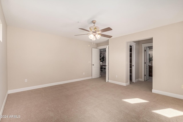 spare room featuring light carpet and ceiling fan