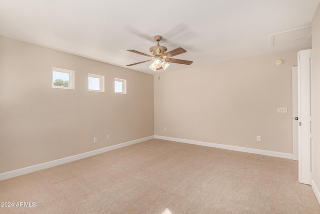 spare room with ceiling fan and light colored carpet