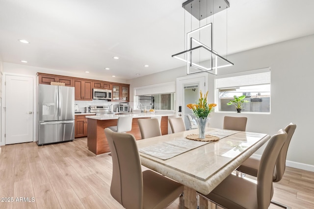 dining space with sink and light hardwood / wood-style floors