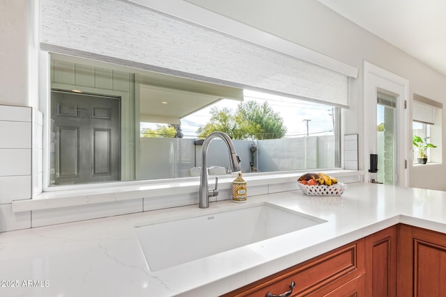 interior space featuring light stone countertops and sink