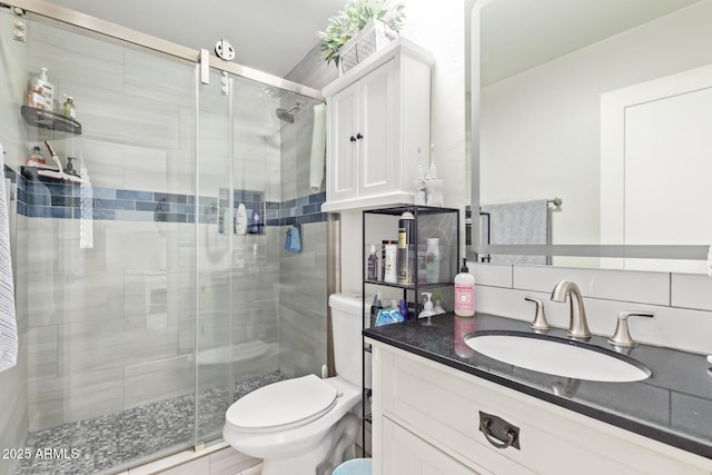 bathroom featuring vanity, toilet, an enclosed shower, and backsplash