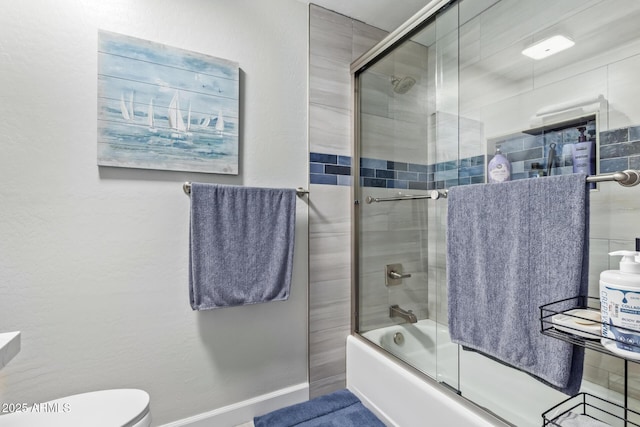 bathroom featuring toilet and combined bath / shower with glass door