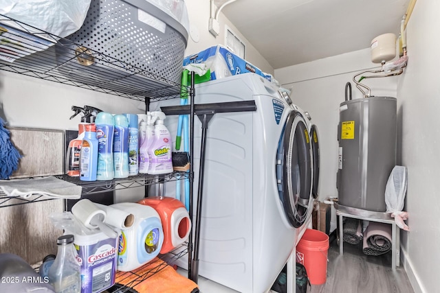 laundry area with independent washer and dryer, hardwood / wood-style flooring, and electric water heater