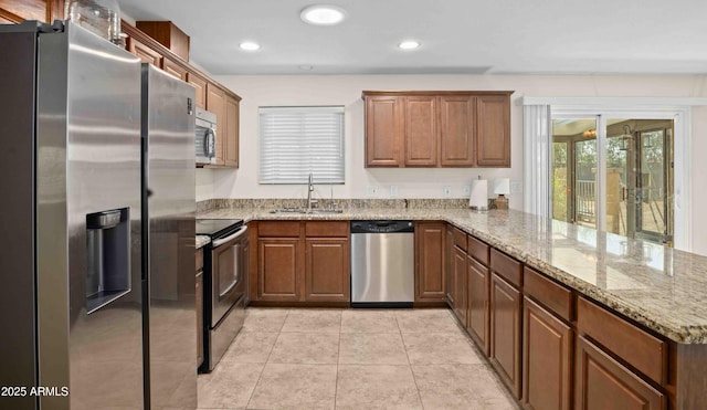 1158 N Barkley St, Mesa, AZ 85203 - kitchen with appliances with stainless steel finishes, a peninsula, light stone counters, brown cabinets, and recessed lighting