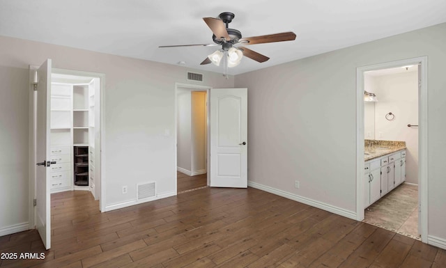 1158 N Barkley St, Mesa, AZ 85203 - unfurnished bedroom with a spacious closet, wood finished floors, a closet, connected bathroom, and a ceiling fan