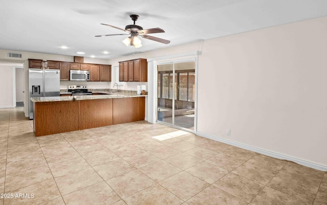 1158 N Barkley St, Mesa, AZ 85203 - kitchen with stainless steel appliances, a peninsula, a ceiling fan, recessed lighting, and light stone counters