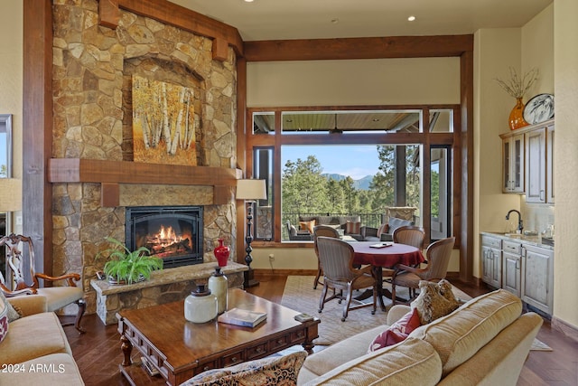 living room with beamed ceiling, a fireplace, dark hardwood / wood-style floors, and sink