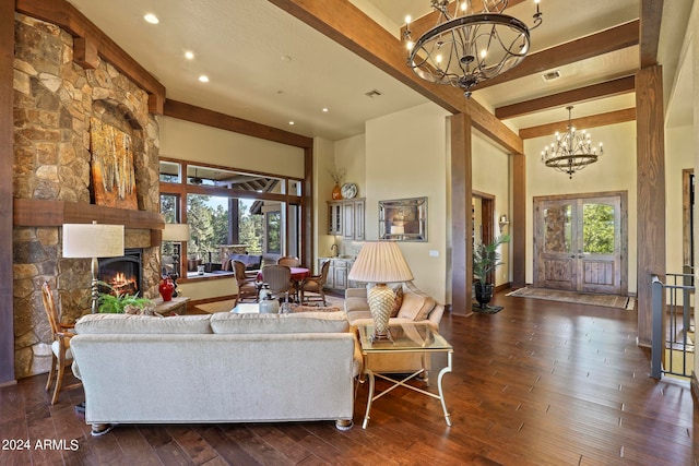 living room with a high ceiling, beam ceiling, dark wood-type flooring, and a stone fireplace