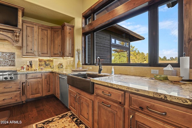 kitchen featuring light stone countertops, decorative backsplash, dark wood-type flooring, sink, and appliances with stainless steel finishes