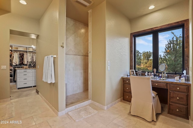 bathroom featuring vanity and tiled shower