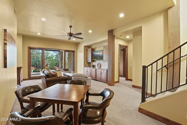 carpeted dining room with ceiling fan and a textured ceiling