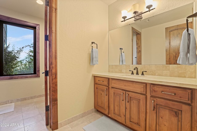 bathroom featuring decorative backsplash, tile patterned flooring, and vanity