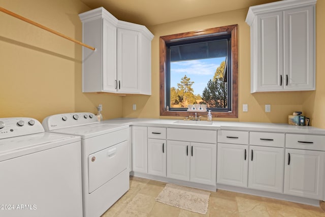 washroom featuring cabinets, sink, and washer and dryer