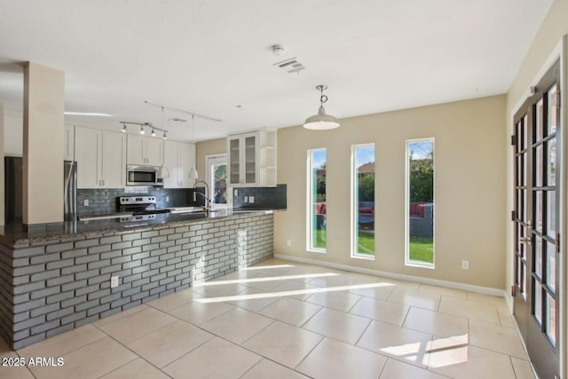 kitchen featuring decorative light fixtures, visible vents, appliances with stainless steel finishes, white cabinetry, and dark stone counters