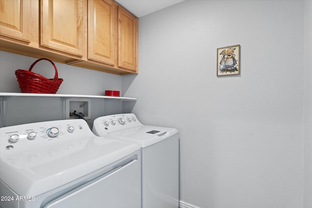 clothes washing area featuring cabinets and washer and clothes dryer