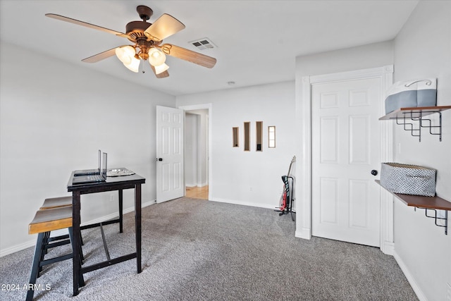 carpeted office space featuring ceiling fan