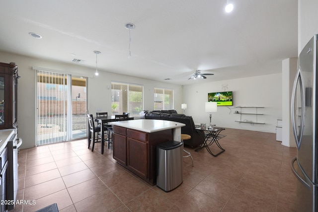 kitchen with visible vents, light countertops, dark tile patterned floors, and freestanding refrigerator