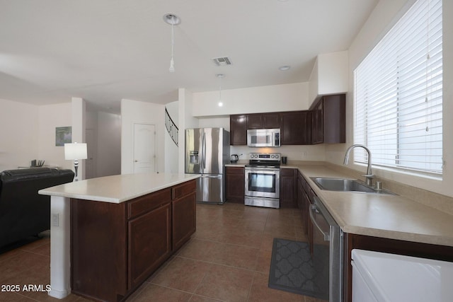 kitchen featuring light countertops, appliances with stainless steel finishes, a sink, and visible vents