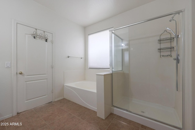 bathroom with a stall shower, a garden tub, and tile patterned floors