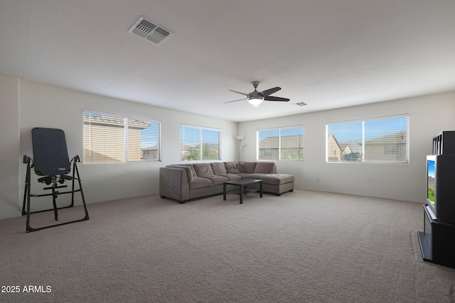 carpeted living area with visible vents and a ceiling fan