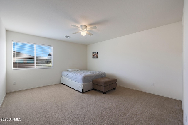 bedroom featuring a ceiling fan, visible vents, and light colored carpet