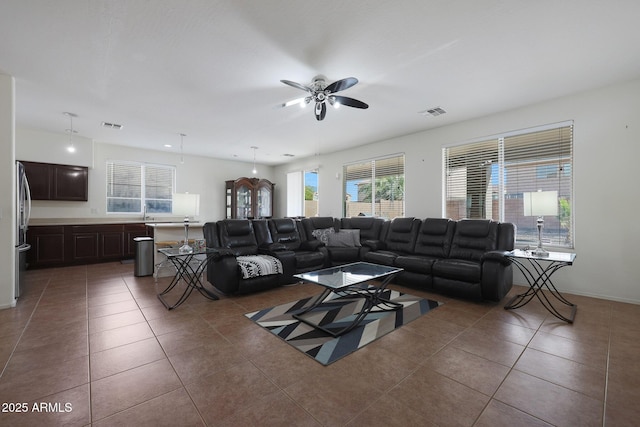 living area with visible vents, a ceiling fan, and tile patterned floors