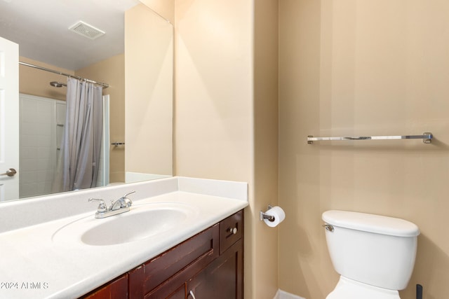 bathroom with toilet, vanity, and a shower with shower curtain