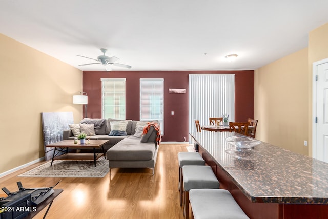 living room with light wood-type flooring and ceiling fan