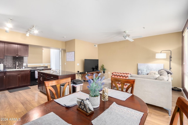 dining area featuring sink, light wood-type flooring, and ceiling fan