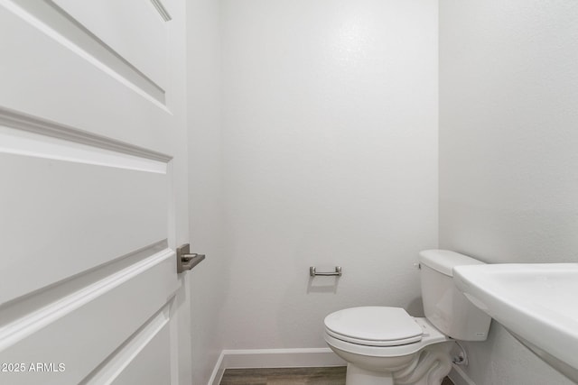 bathroom with sink, wood-type flooring, and toilet