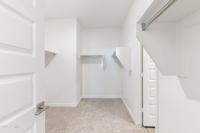 walk in closet featuring light carpet