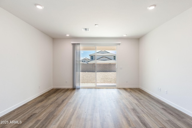 unfurnished room with hardwood / wood-style flooring